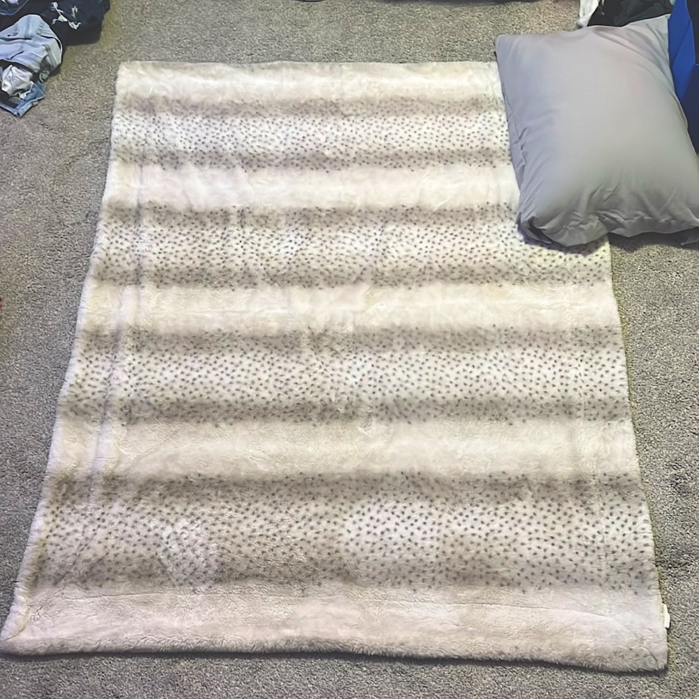 A white tan soft cheetah blanket.